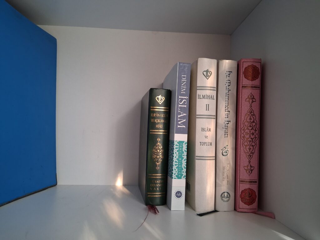 Namaz odası dekorasyonu Kur'an-ı Kerim, Meal ve temel İslami eserlerin bulunduğu minimalist kitaplık rafı.